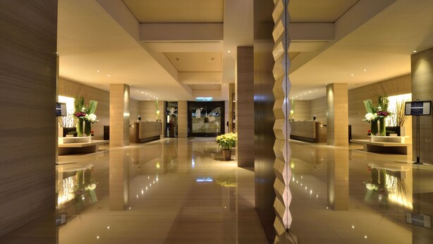 A modern hotel lobby with a polished floor, symmetrical design, and decorative plants. - Les Suites Taipei Ching Cheng (Taipei)