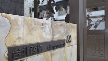 A sign with the name "Ching Cheng" and a number "12" on a stone wall.