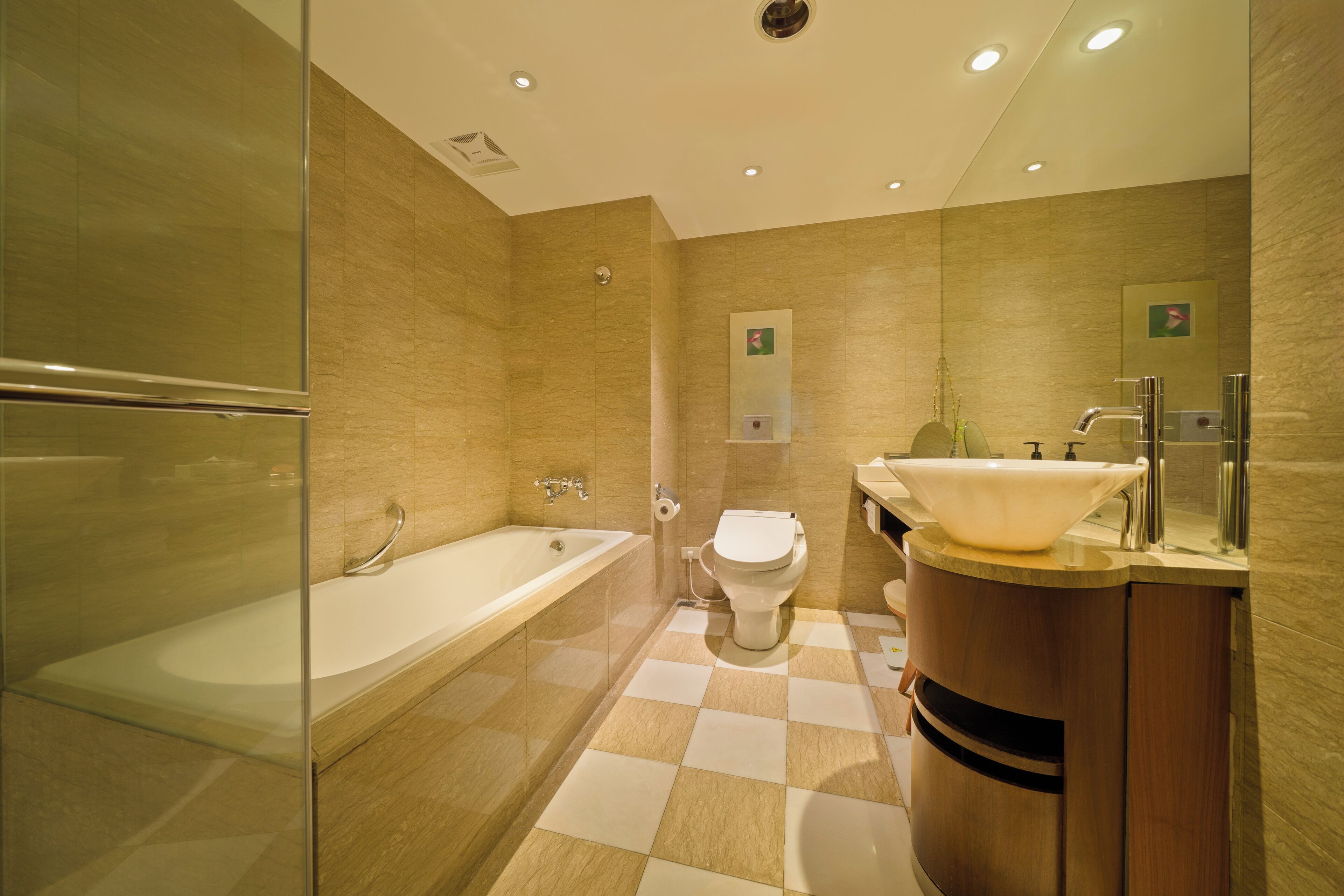 Un baño moderno con cabina de ducha de vidrio, bañera independiente, inodoro y tocador con lavamanos.