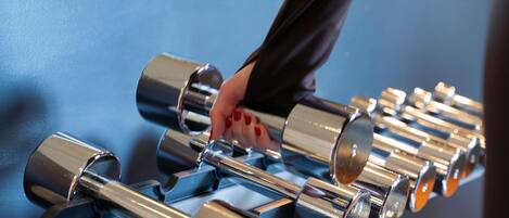 A hand adjusting a series of metallic cylindrical objects, likely part of a mechanical or industrial setup.