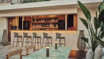 An outdoor bar area with a tiled floor, bar counter, and seating arrangement.