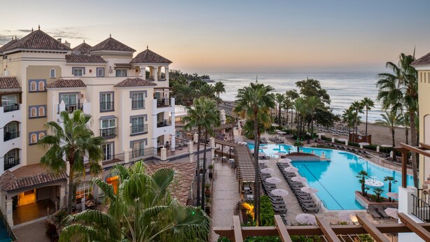 A resort with a pool, palm trees, and a view of the ocean. - Marriott's Playa Andaluza (Estepona)