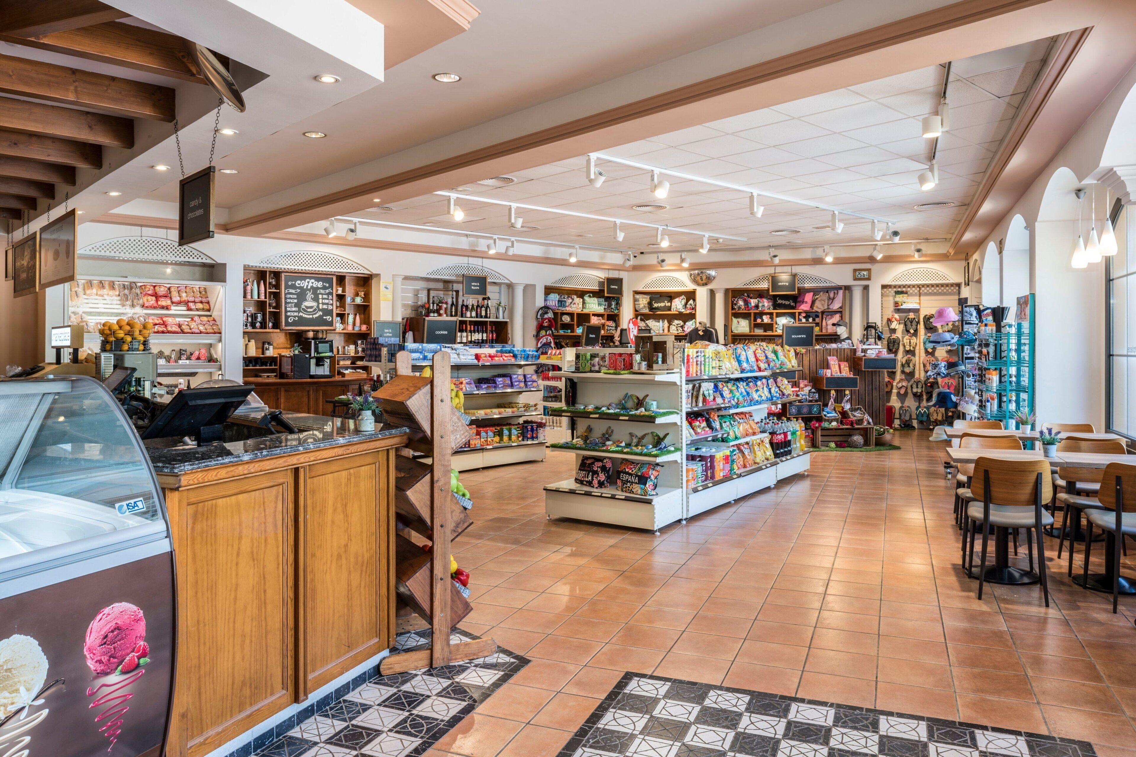 A spacious indoor market with various stalls and shelves stocked with goods.