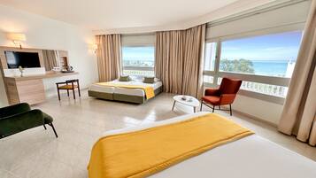A hotel room with a bed, a desk, a chair, and a TV.