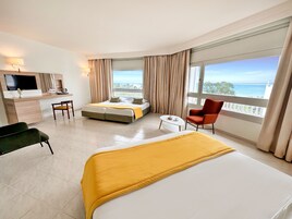 Una habitación de hotel con cama, escritorio, silla y televisor.