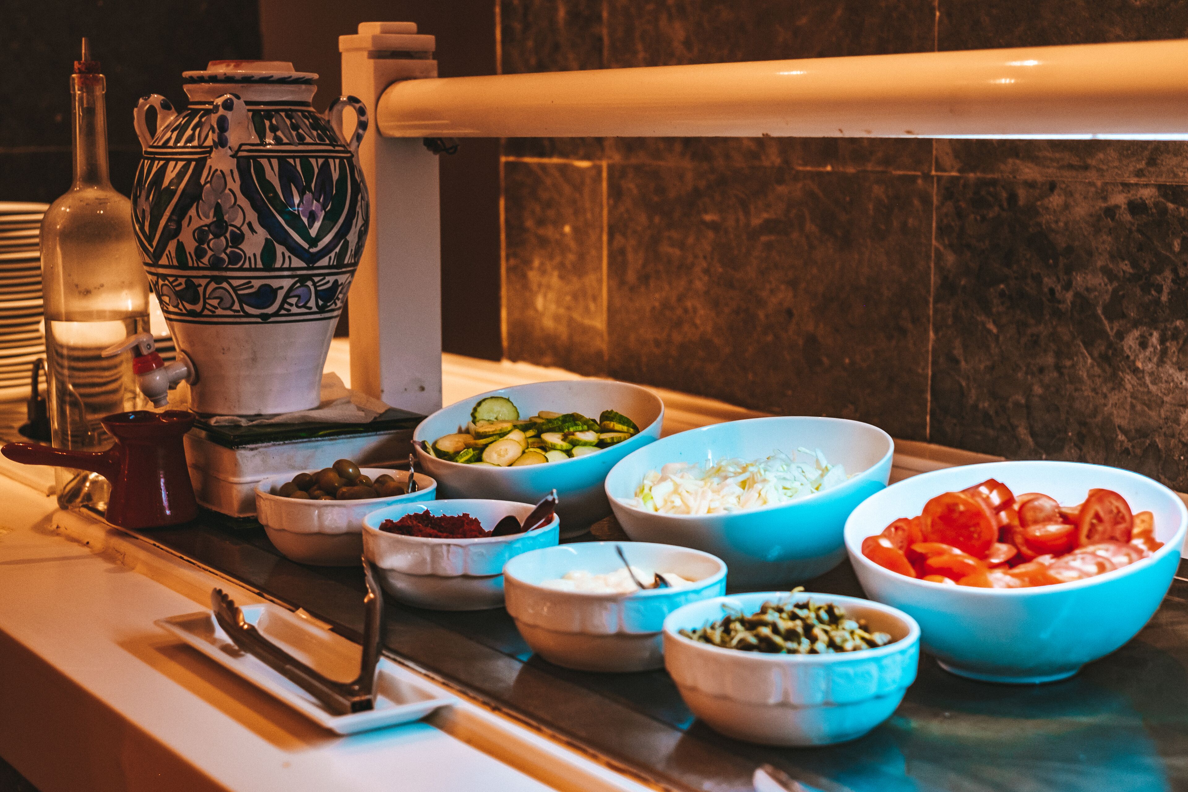 Una mesa de buffet con diferentes alimentos y utensilios de servicio.