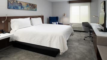 Une chambre d’hôtel moderne équipée d’un grand lit, d’un bureau, d’une chaise et d’un téléviseur.