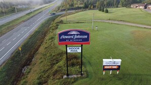 A sign for Howard Johnson by Wyndham with an indoor pool and an exit sign. - Howard Johnson by Wyndham Woodstock NB (Woodstock)