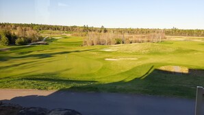 A golf course with a clear sky, well-maintained grass, and a few trees in the background. - Howard Johnson by Wyndham Woodstock NB (Woodstock)