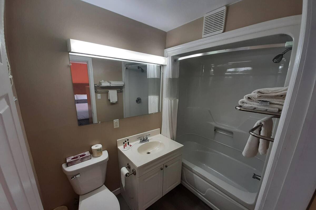 A bathroom with a toilet, sink, and shower.