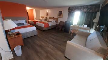Een hotelkamer met twee bedden, een bank, een bureau en een stoel.