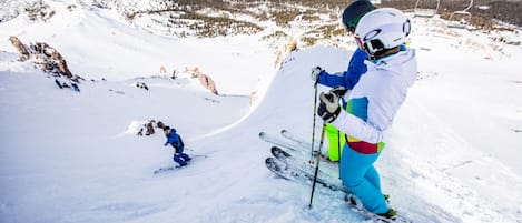 Une piste de ski enneigée, avec un télésiège en arrière-plan.