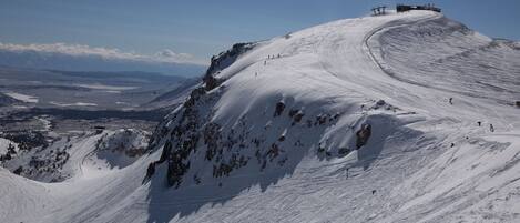 A snow-covered mountain with a ski lift and a chairlift.