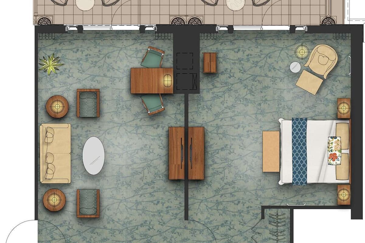 A hotel room layout with a dining area, a sitting area with a sofa and chairs, a bed, a bathroom, and a kitchen.