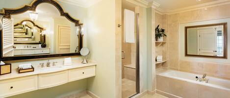 A spacious bathroom with a large mirror, a bathtub, and a shower area.