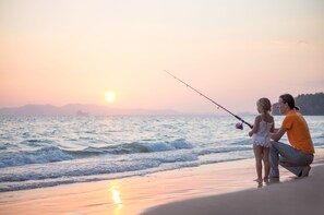 A couple fishing on a beach during sunset. - Mackay Seabreeze Apartments (Slade Point)
