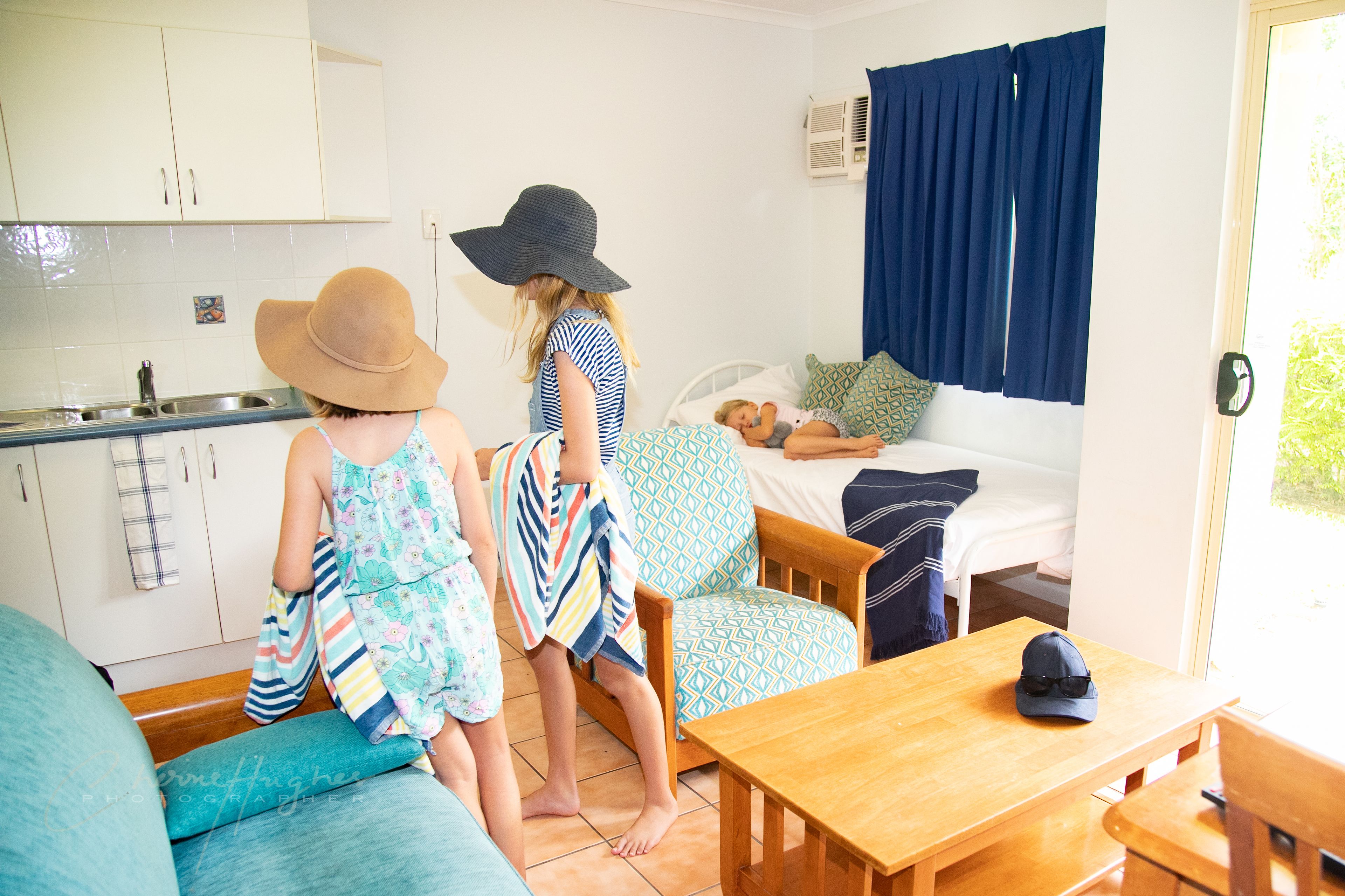 Una habitación acogedora con cama, una mesa de madera, un sofá y una zona de cocina.