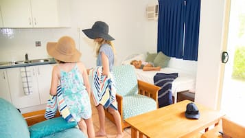 Una habitación acogedora con cama, una mesa de madera, un sofá y una zona de cocina.