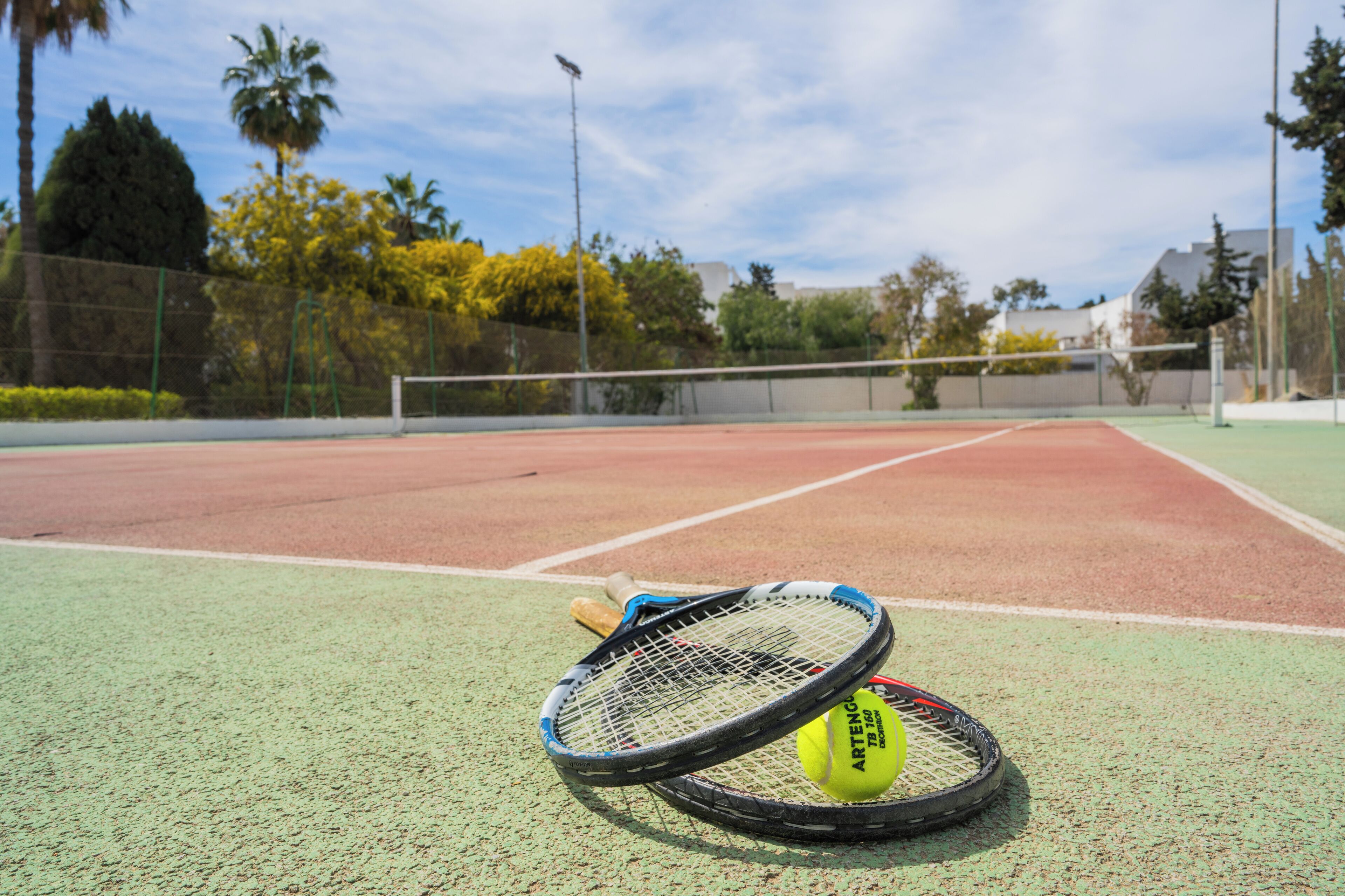 Un court de tennis avec un filet, une raquette de tennis et une balle de tennis.
