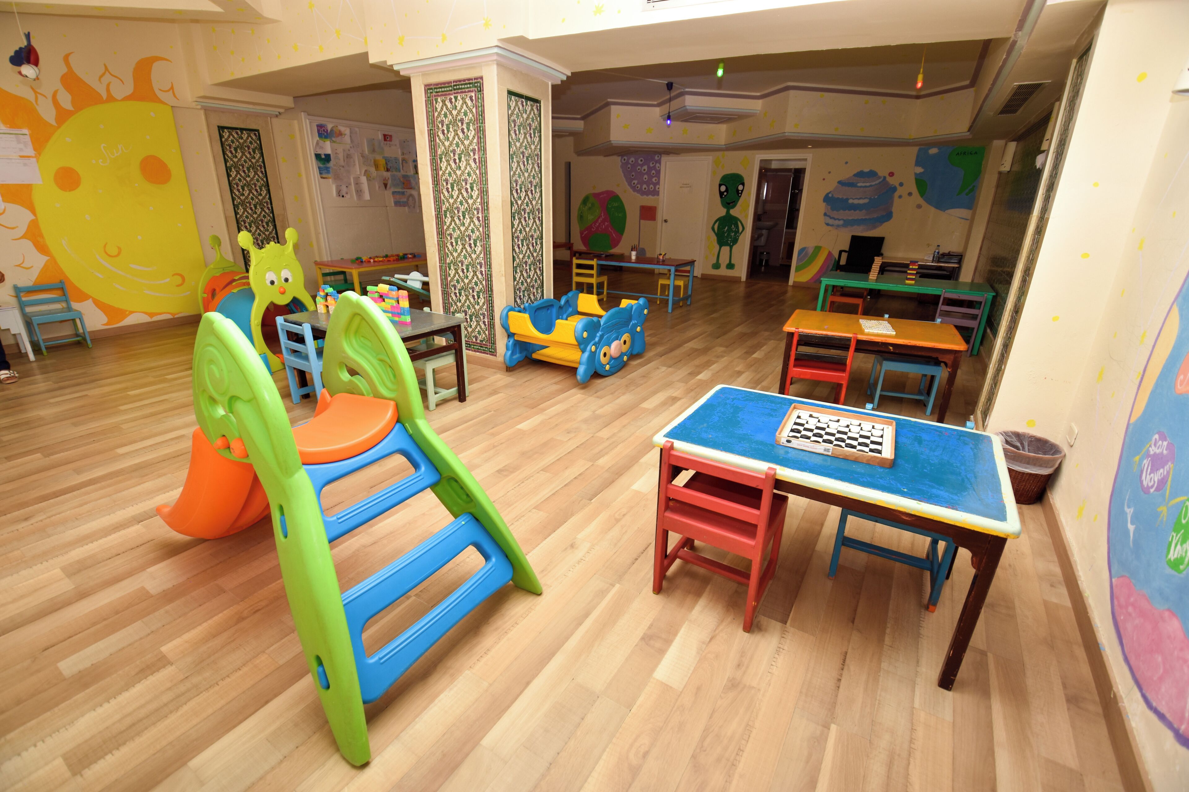 A children's play area with colorful furniture and educational decorations.