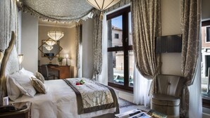 Una habitación de hotel bien equipada con una cama grande, un escritorio, una silla y un televisor.