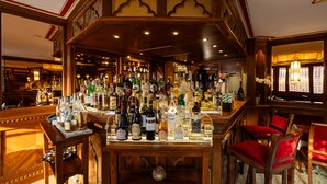 Zona de bar con mobiliario de madera y una variedad de botellas de licor.