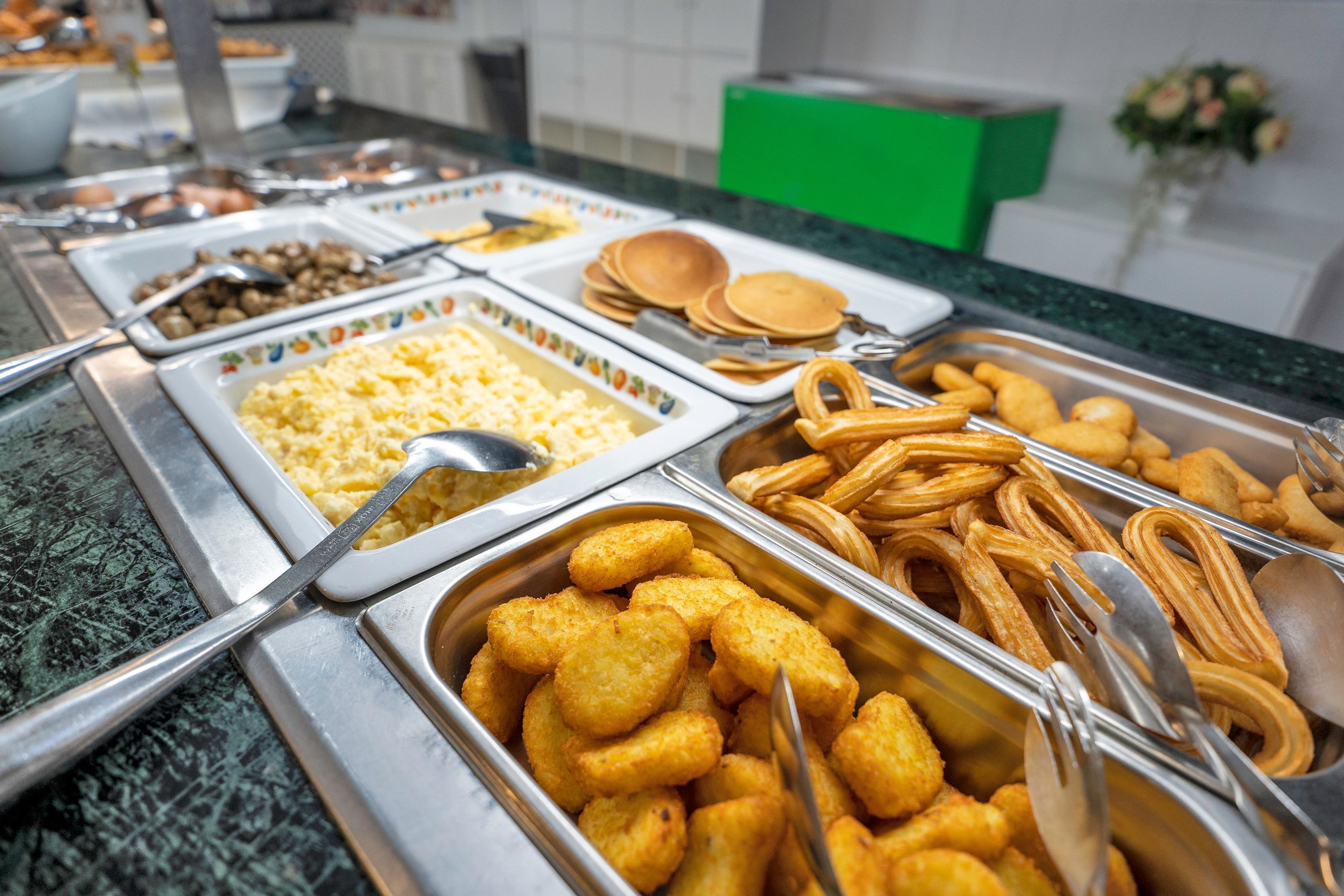 A buffet with various food items in metal containers.
