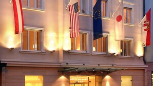 Un hôtel à plusieurs étages, doté de grandes fenêtres et de drapeaux.