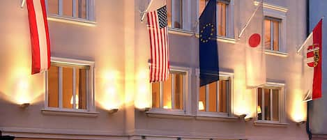 A hotel with multiple floors, large windows, and flags.