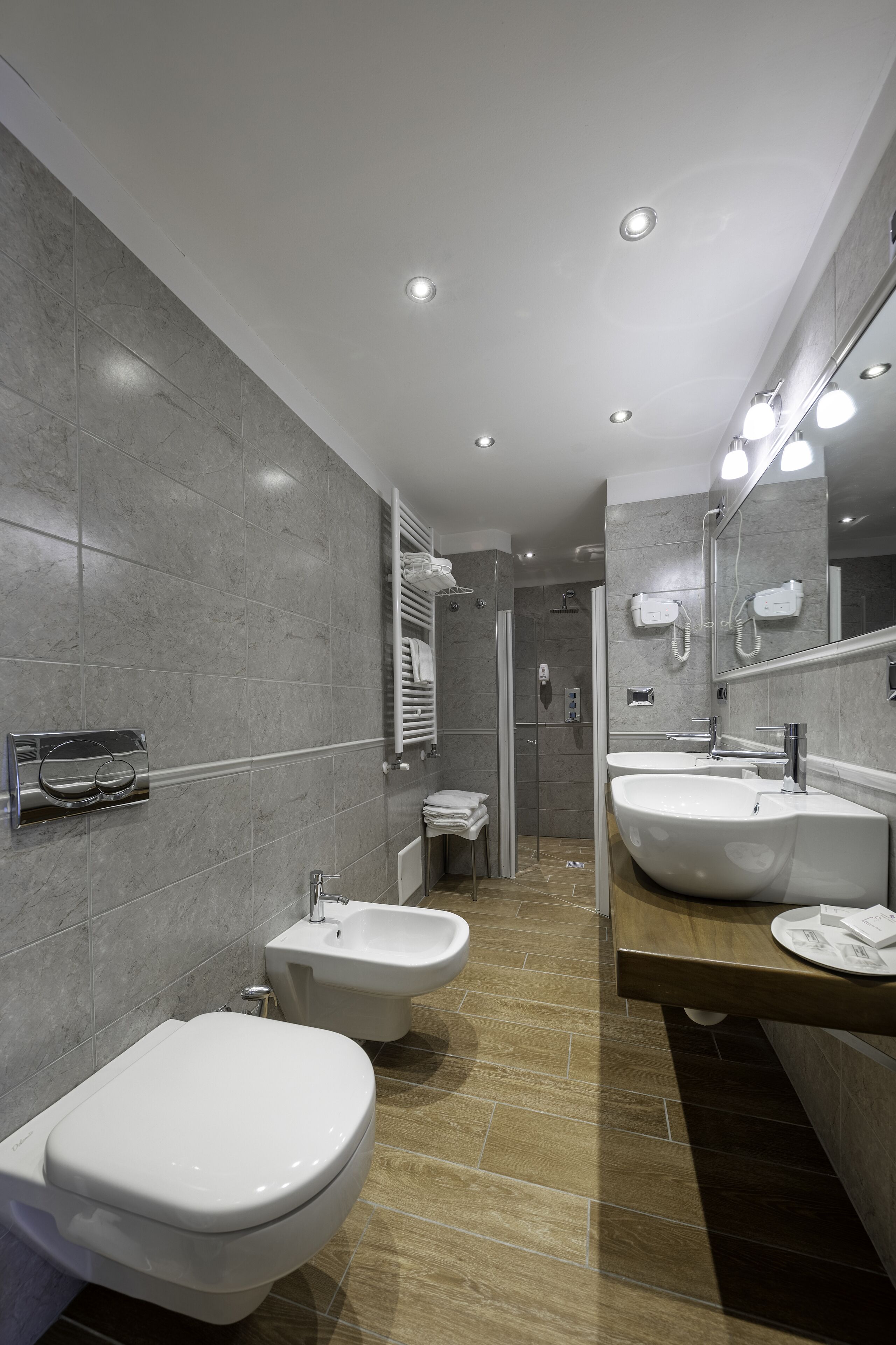 Ein modernes Badezimmer mit zwei Waschbecken, einer Toilette und einer Dusche.