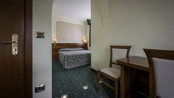 Una habitación de hotel con una cama, un escritorio y una silla.