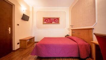 A small, neatly arranged bedroom with a wooden bed, a bench, a mounted TV, and a framed artwork on the wall.