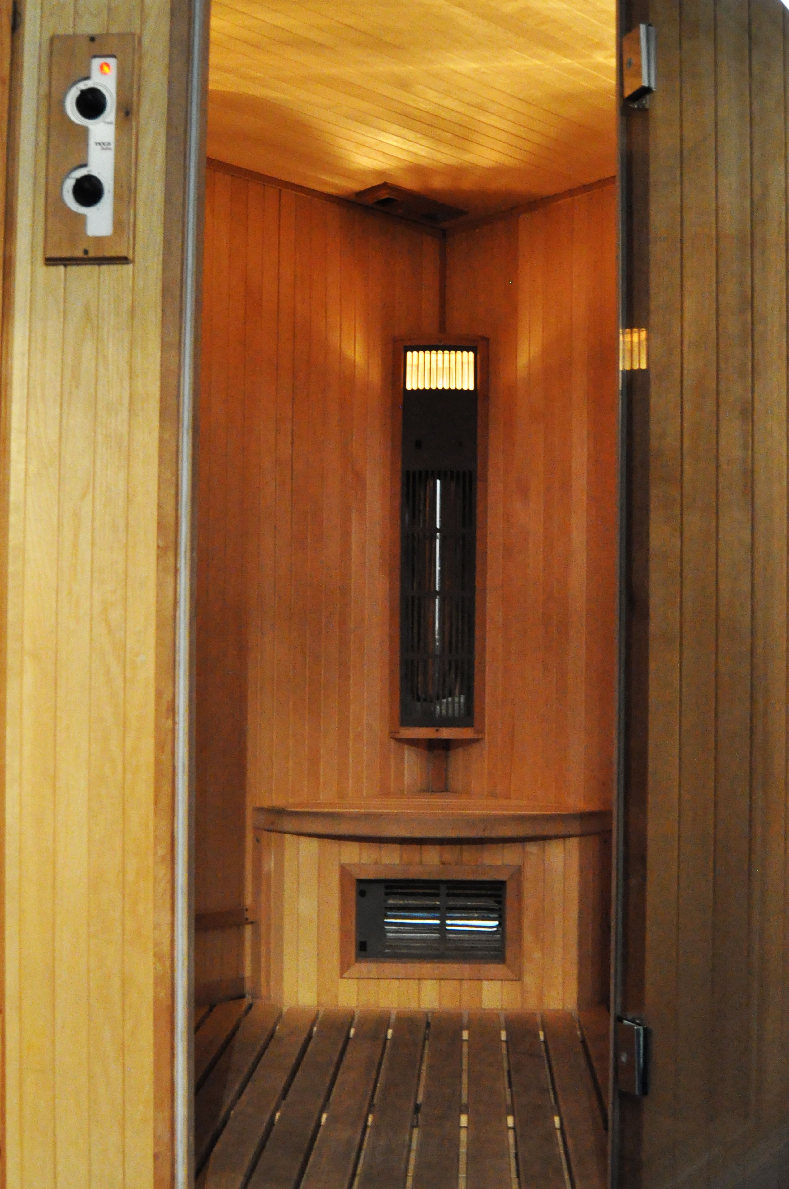 Una sauna con paredes de madera, un banco y un sistema de ventilación.