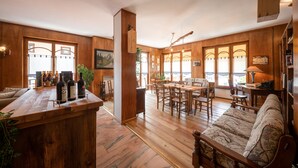 Un vaste espace de vie doté d’un plancher en bois, d’un comptoir de bar en bois et d’un canapé.
