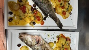 A white plate with a whole fish and roasted potatoes. - Hotel Le Ville (Capannori)