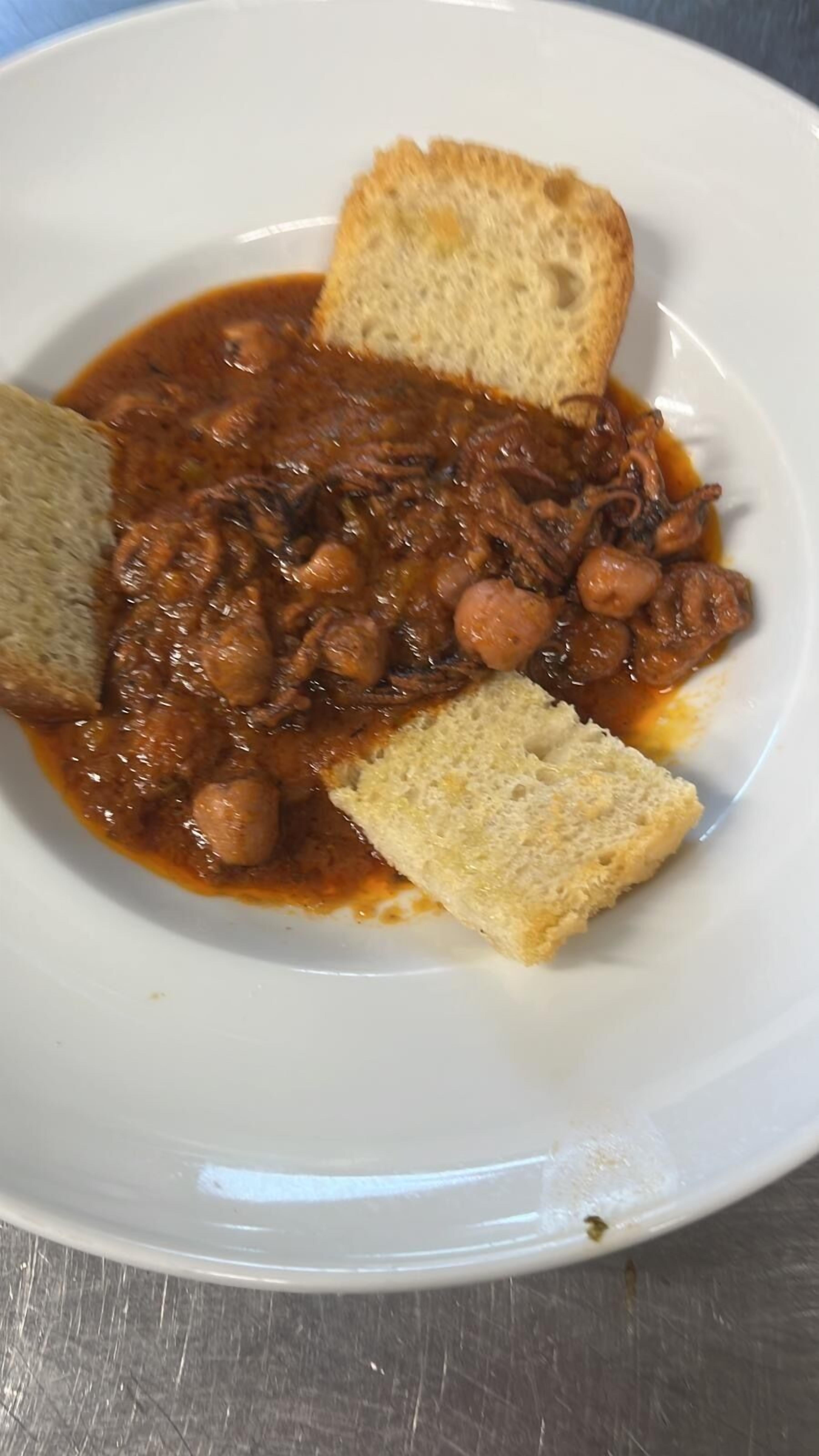 Un plato con estofado y pan.