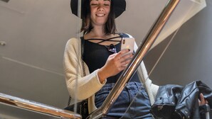 Una persona tomándose un selfie en un interior moderno con una lámpara esférica singular.