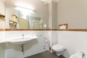 Un baño con lavamanos, inodoro y ducha.