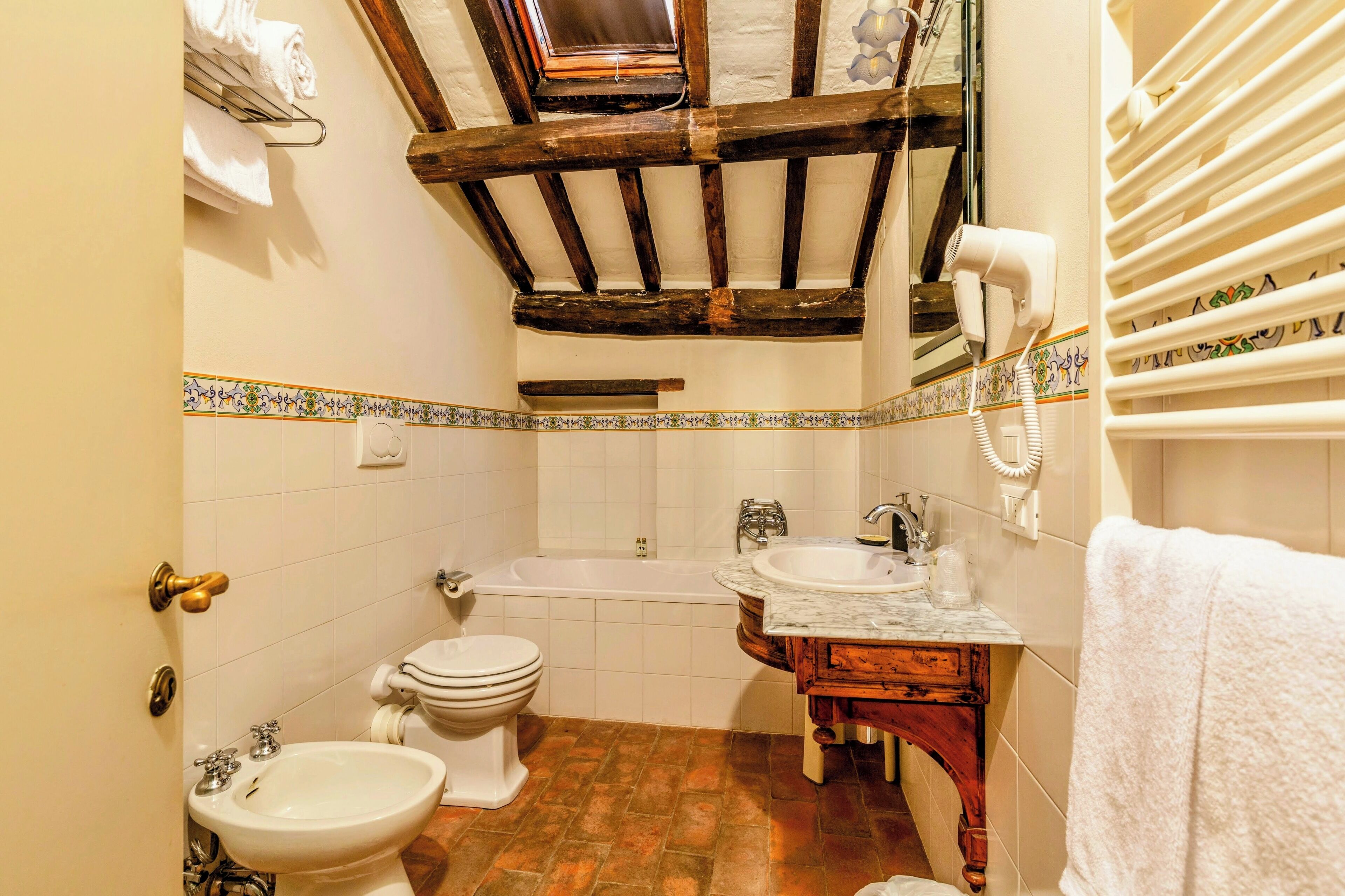 Une salle de bain comprenant une baignoire, un lavabo, des toilettes et un meuble-lavabo avec un miroir.