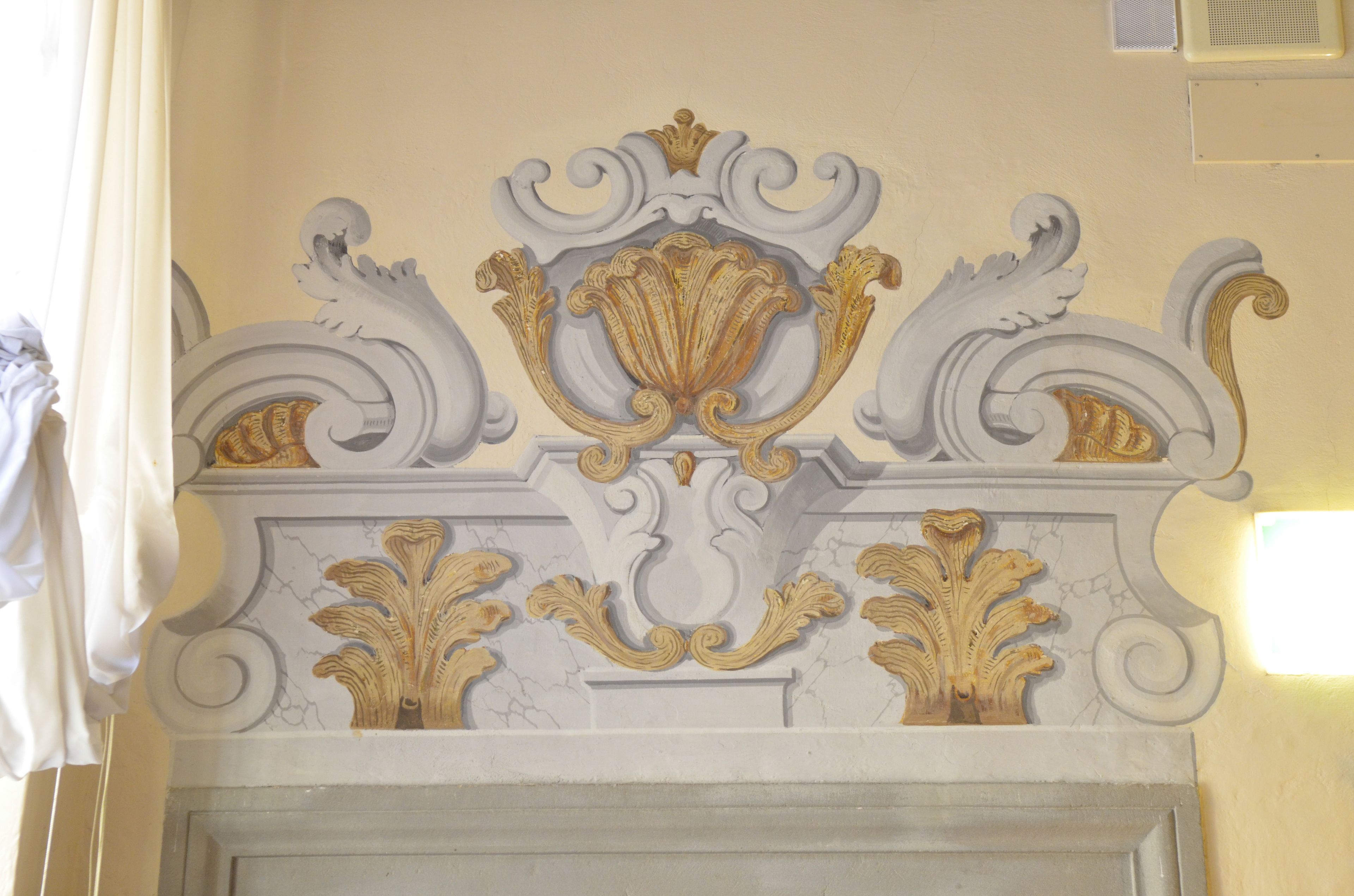 Un plafond richement décoré, orné de motifs dorés et blancs.