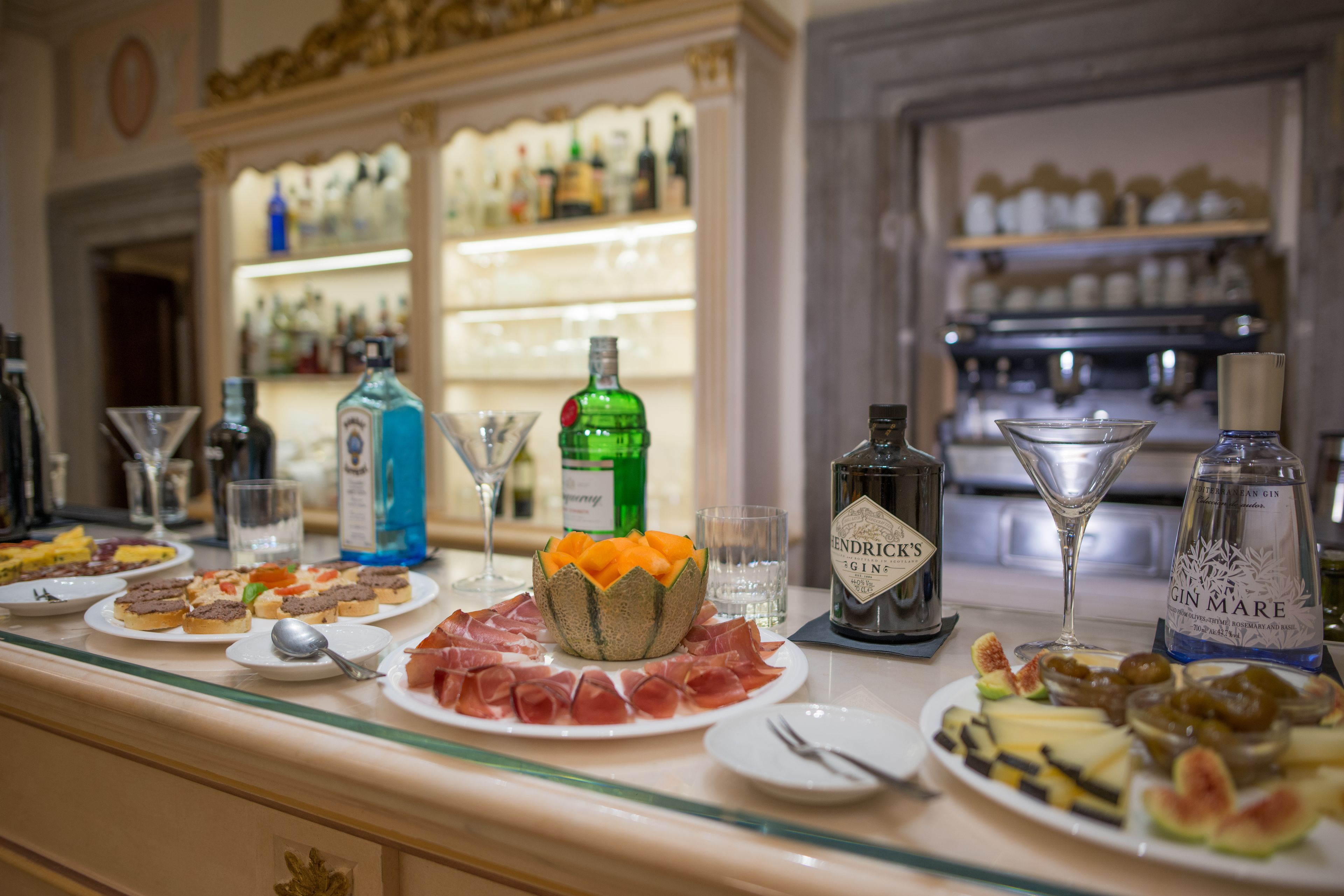 A bar area with various food items, drinks, and a selection of bottles.