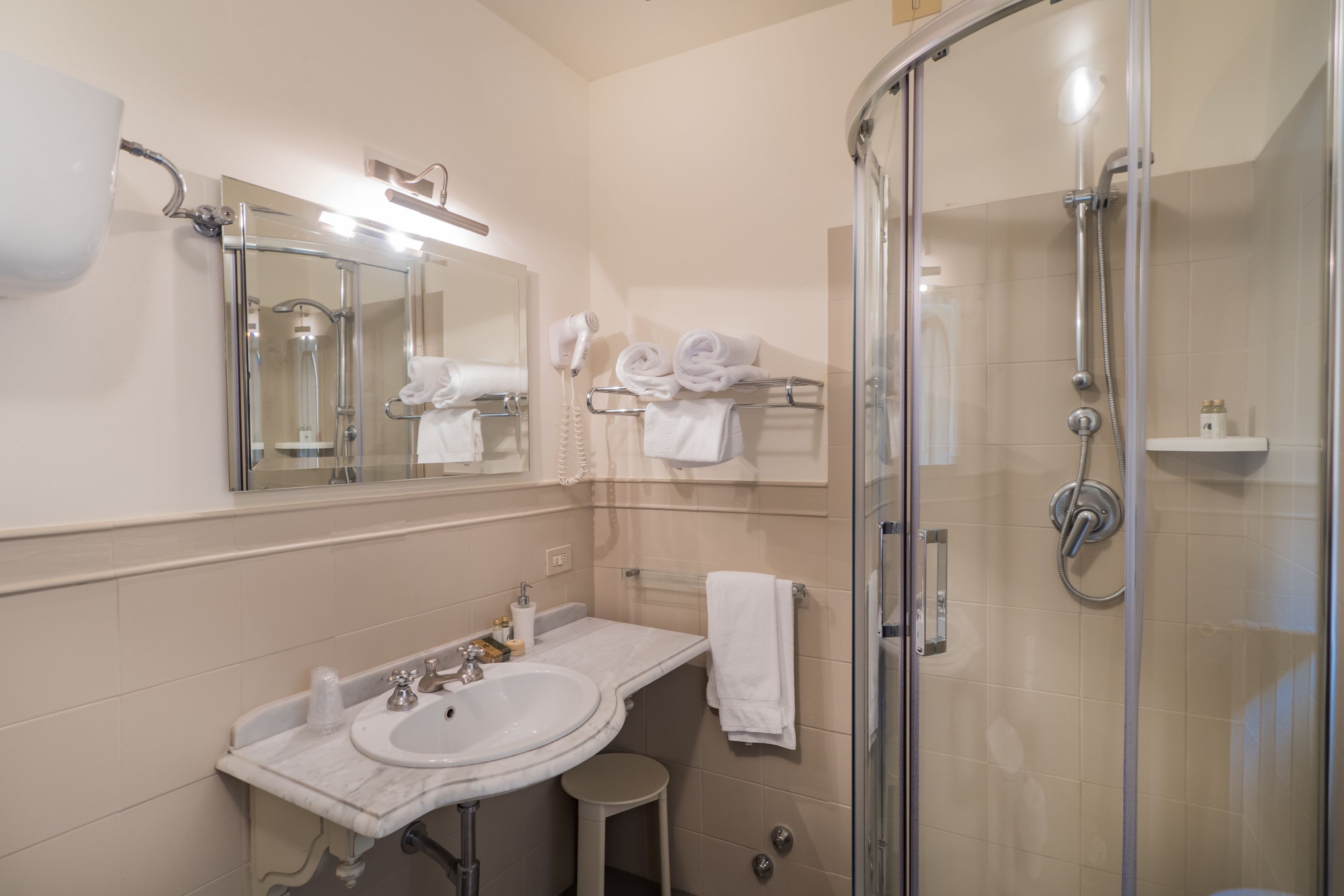 A modern bathroom with a glass-enclosed shower, a double sink vanity, and a large mirror.