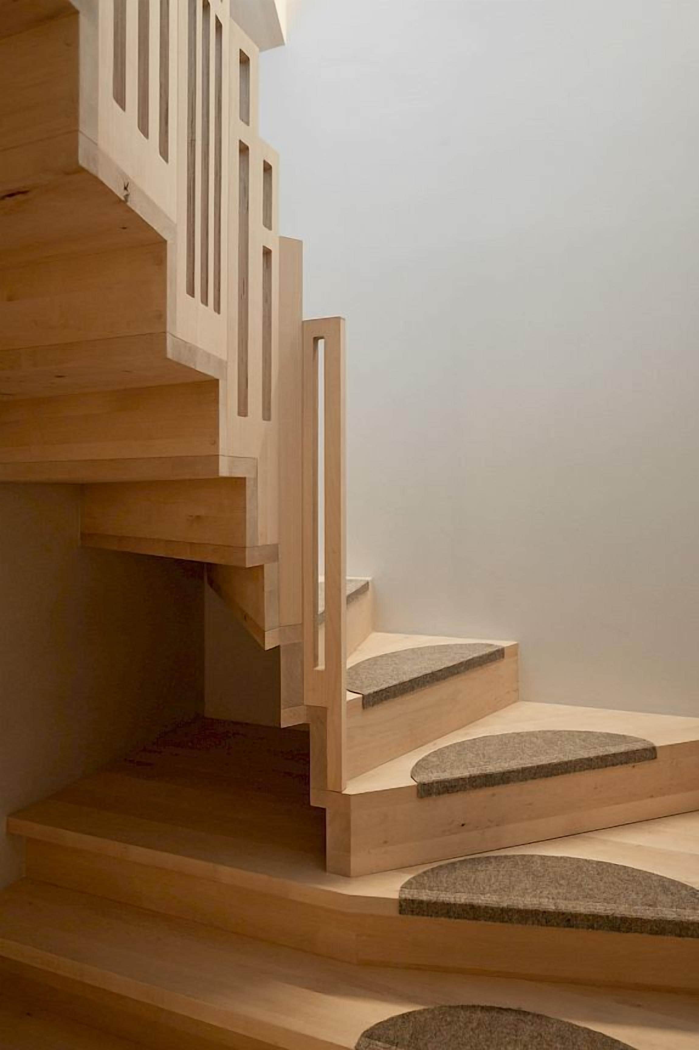 Una escalera de madera con diseño moderno, que cuenta con una barandilla recta y una serie de escalones que ascienden.