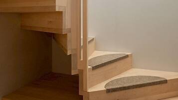 Una escalera de madera con diseño moderno, que cuenta con una barandilla recta y una serie de escalones que ascienden.