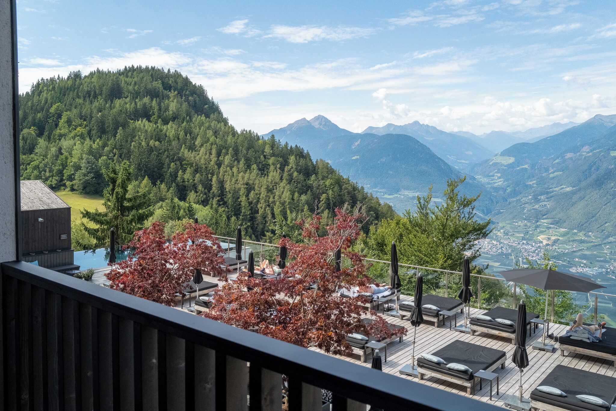 Un balcón con mobiliario exterior, con vista a un paisaje montañoso.