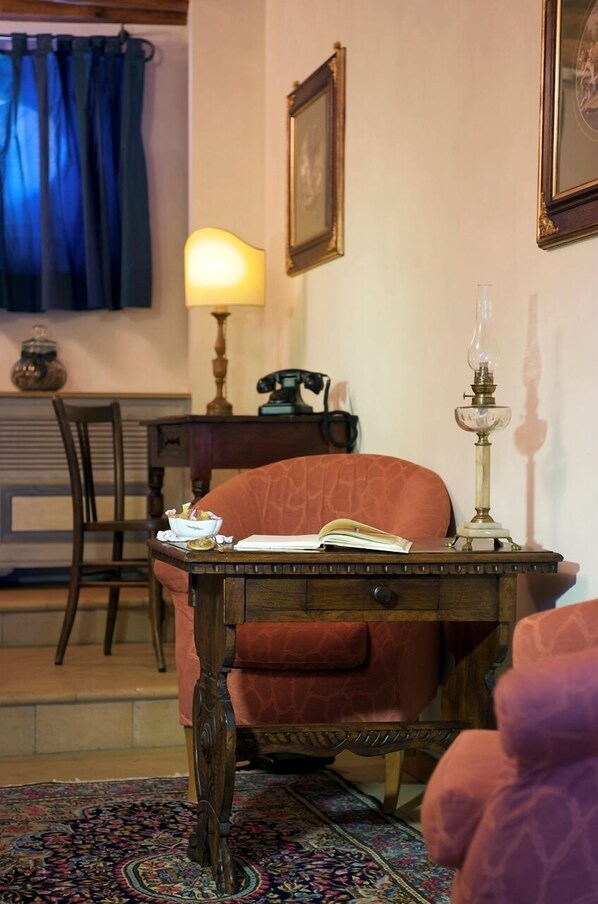 A cozy room with a wooden desk, a chair, a lamp, and a framed picture on the wall. - Palazzo Leti Residenza d'Epoca (Spoleto)