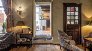 Una habitación acogedora con muebles escoceses, una puerta de madera y una estantería con diversos objetos.