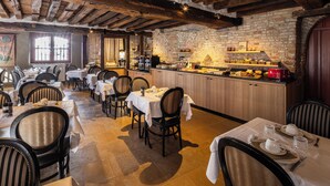 Un restaurante con vigas de madera, paredes de ladrillo y mesas preparadas para comer.