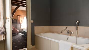 Une salle de bain avec une baignoire, une douche et une serviette accrochée sur le côté.