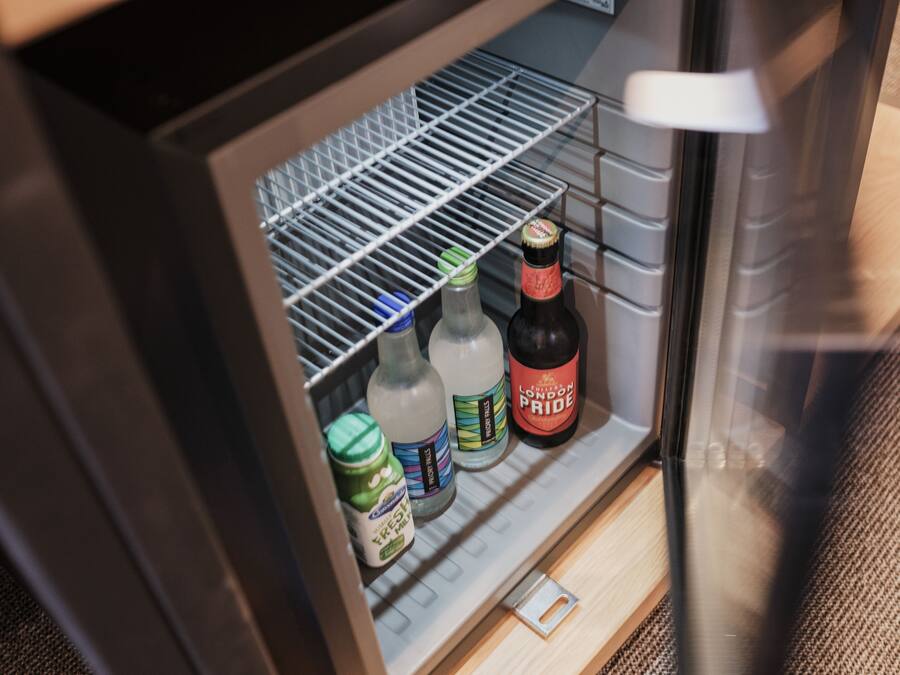 A refrigerator with shelves containing various beverages and condiments.